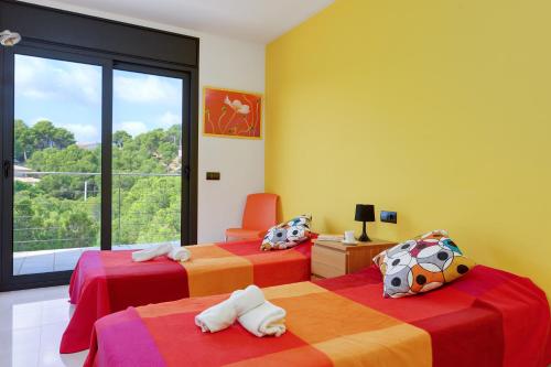 a bedroom with two beds and a large window at Naranja in Tamariu