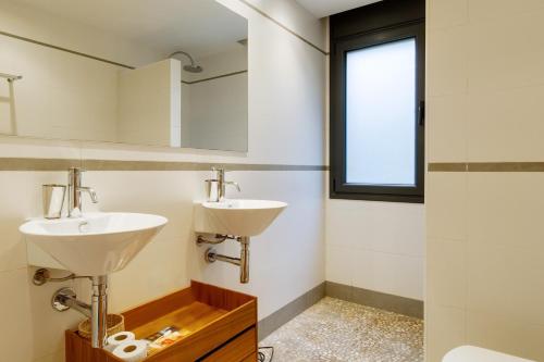 a bathroom with two sinks and a mirror at Naranja in Tamariu