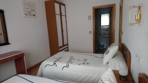 a bedroom with two beds with writing on the sheets at Hostal "Los Chanos el Ruso" in Galende