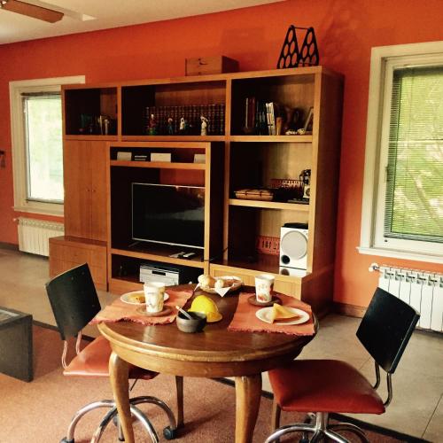 ein Wohnzimmer mit einem Tisch und einem Fernseher in der Unterkunft Villa Vert in Beccar