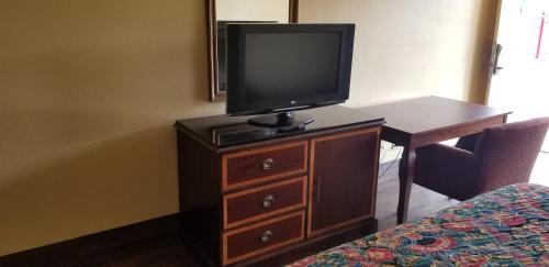 einen Fernseher auf einer Kommode in einem Hotelzimmer in der Unterkunft Family Inns of America - Mobile in Mobile