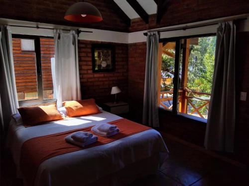Un dormitorio con una cama con dos sombreros. en Apart Peumayen en San Martín de los Andes
