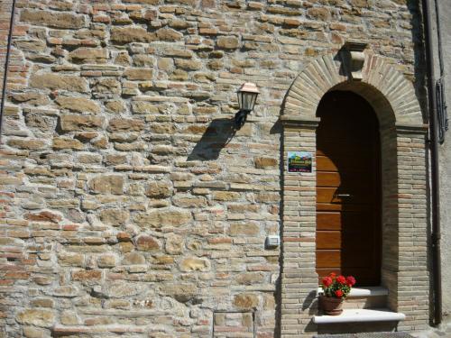 a brick wall with a lamp and a flower pot at Nidastore Holidays in Arcevia