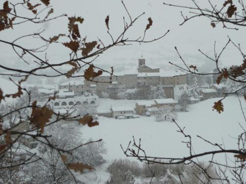 a city covered in snow with a town in the background at Nidastore Holidays in Arcevia
