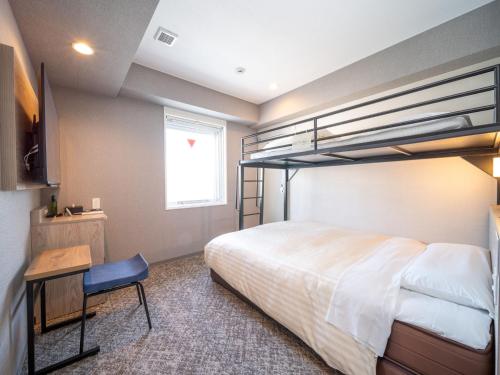 a bedroom with a bunk bed and a desk at Super Hotel Mitazono Sendai Airport in Natori