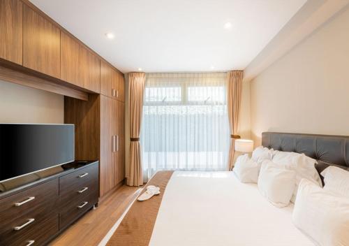 1 dormitorio con 1 cama grande y TV de pantalla plana en Lamartine 619 Residencial, en Ciudad de México