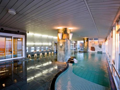 a large swimming pool in a building with a pool at Mikawa Bay Hills Hotel in Nishio