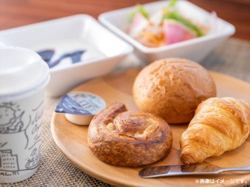 a plate of bread and pastries on a table at Super Hotel Mitazono Sendai Airport in Natori