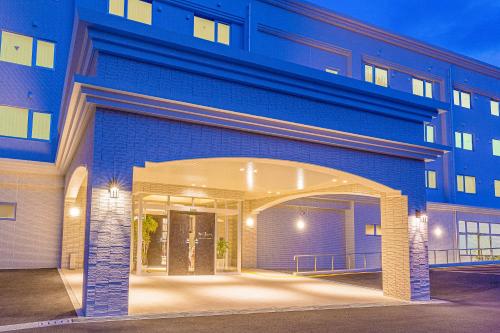 a blue building with an archway in front of it at Morinoyu Resort in Beppu