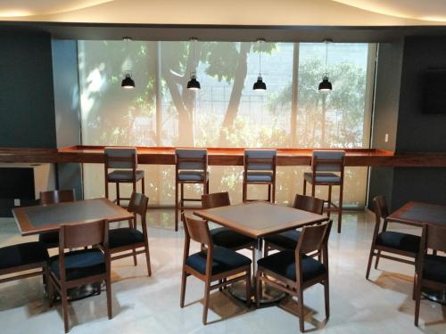 a restaurant with tables and chairs and a window at Holiday Inn Express Mexico Reforma by IHG in Mexico City