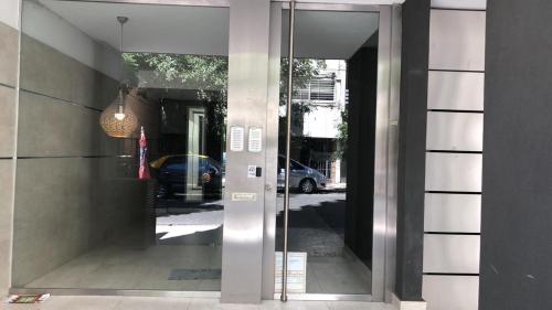 a glass door of a building with a reflection of a street at 9 de Julio 2200 in Rosario