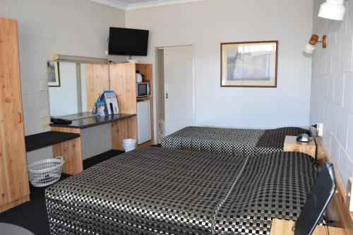 Zimmer mit einem Bett mit einer schwarzen und weißen Bettdecke in der Unterkunft Black Diamond Motel in Blackwater