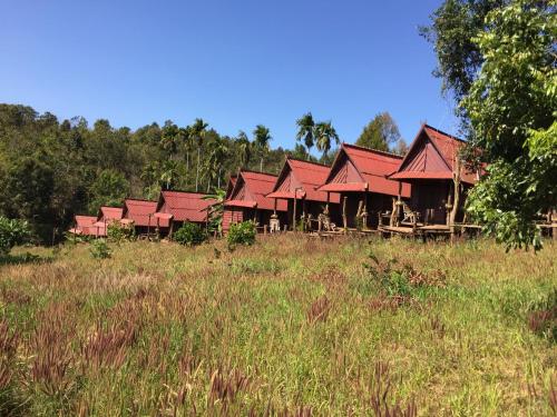 a row of houses with red roofs in a field at Tree Lodge in Sen Monorom