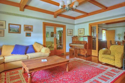 a living room with a couch and a piano at Melville House Bed and Breakfast in Lismore