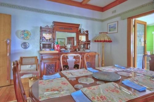 a dining room with a table with chairs and a mirror at Melville House Bed and Breakfast in Lismore