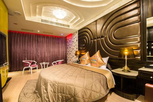 Zheng Yi Classic Hotel & Motel في مدينة تايتونج: غرفة نوم بسرير وطاولة وكراسي