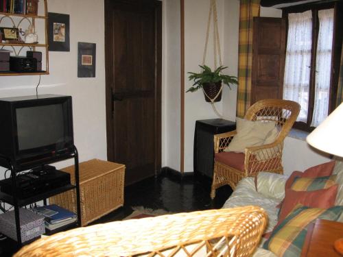 een woonkamer met rieten stoelen en een televisie bij Casa Turpesa in Peñalba de Santiago