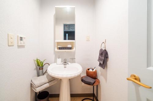 La salle de bains blanche est pourvue d'un lavabo et d'un miroir. dans l'établissement Sea Side TOYA 302, à Yomitan