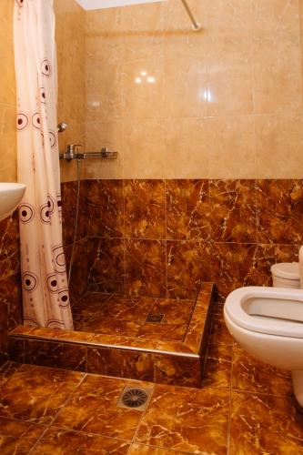 a bathroom with a shower with a toilet and a sink at Nikos Hotel in Karterados