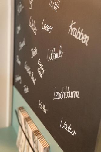 a chalkboard with the names of restaurants on it at Deichhotel Grube in Dorum Neufeld