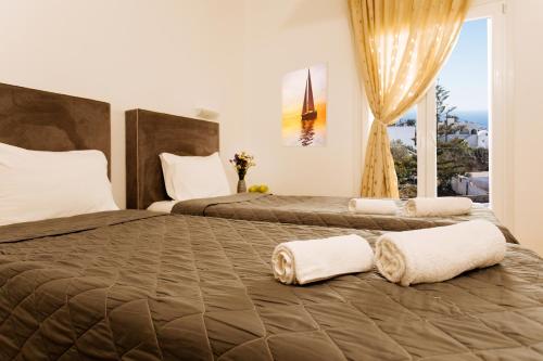 a bedroom with two beds with towels on them at Nikos Hotel in Karterados