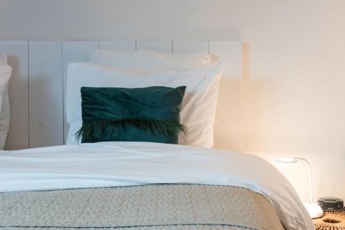 a green pillow sitting on top of a bed at Hof Olmenstein in Goes