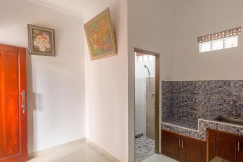 a bathroom with a walk in shower and a sink at Koolkost Syariah at Penginapan Bumi Ahsan in Lembang