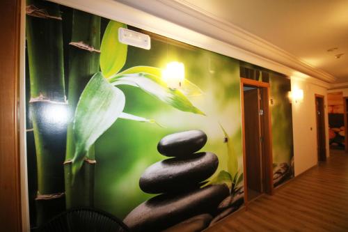 a room with a wall with a painting of three rocks at Hotel Alfonso I in Tui