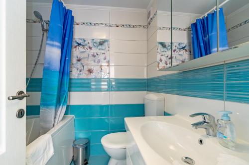 a blue and white bathroom with a sink and a toilet at Castello Rezidence Korcula in Korčula