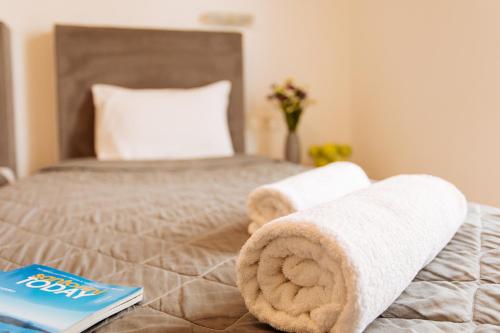 a bedroom with a bed with towels on it at Nikos Hotel in Karterados