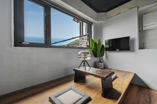 een woonkamer met een tafel en een televisie bij H& Jiufen The Ocean Theory in Jiufen
