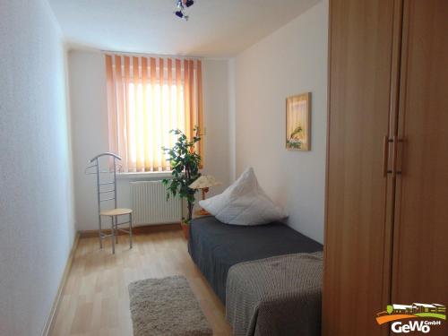a small bedroom with a bed and a window at Ferienwohnung August 30 in Gelenau