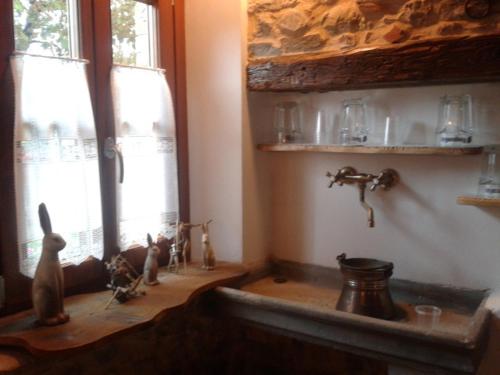 a kitchen with a sink and two windows at Alloggio Agrituristico Conte Ottelio in Pradamano