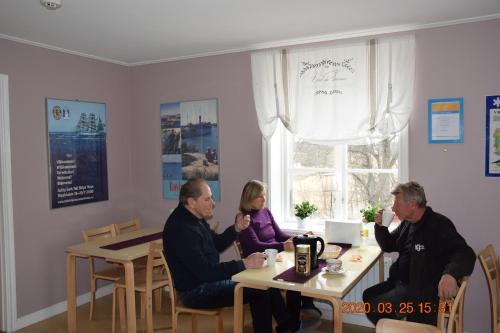 a group of people sitting at tables in a room at STF Kapellskär Hostel in Gräddö