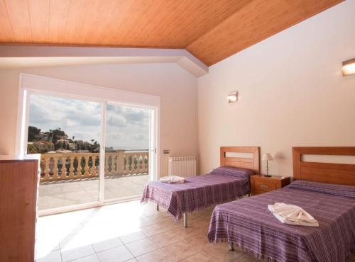 a room with two beds and a balcony at Villa Calypso - Plusholidays in Calpe