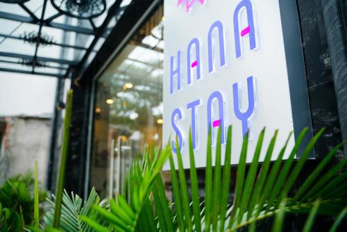 a sign in front of a store with plants in front at HANA Stay in Hanoi
