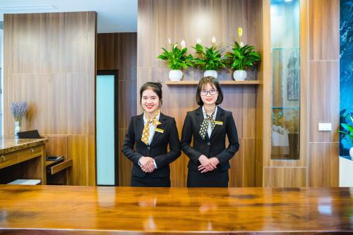 two women standing in front of a table at HANA Stay in Hanoi