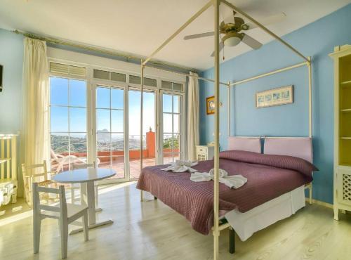 a bedroom with a canopy bed with a table and a tableablish at Villa Eden - Plusholidays in Calpe