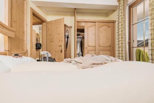 a bedroom with two beds and a closet at Hotel Sieghard Zillertal in Mayrhofen