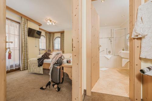 a woman is taking a picture of a bathroom at Hotel Sieghard Zillertal in Mayrhofen