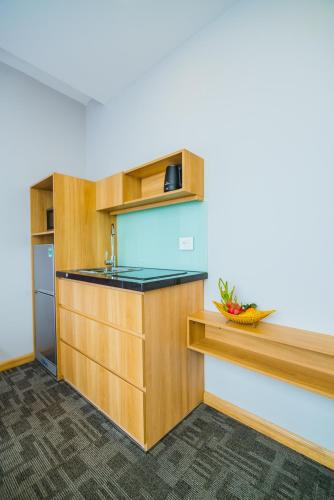 a kitchen with wooden cabinets and a sink at HANA Stay in Hanoi