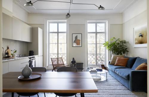 een woonkamer met een blauwe bank en een tafel bij Modern 1 Bedroom Apartment - minutes from Angel Tube St. in Londen