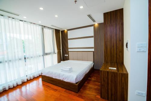 a bedroom with a bed and a large window at HANA Stay in Hanoi