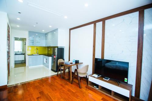 a living room with a television and a table with chairs at HANA Stay in Hanoi