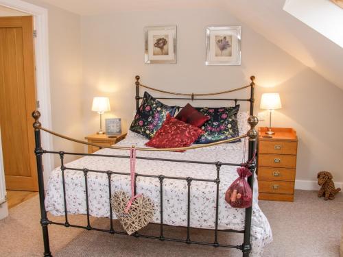 a bedroom with a wrought iron bed with pillows at Cherry Tree Barn in Shrewsbury