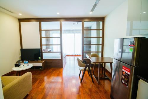 a living room with a refrigerator and a table at HANA Stay in Hanoi