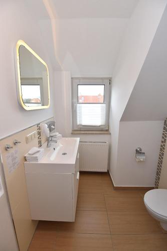 a white bathroom with a sink and a mirror at Bremer Apartmenthotel Superior in Bremen