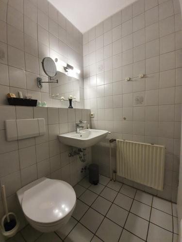 a bathroom with a toilet and a sink at Waldhotel Surwold in Surwold