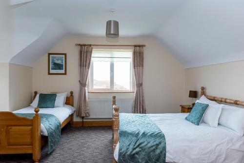 a bedroom with two beds and a window at Portbeg Holiday Homes at Donegal Bay in Bundoran
