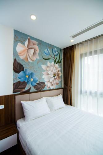 a bedroom with a large bed with a floral wall at HANA Stay in Hanoi